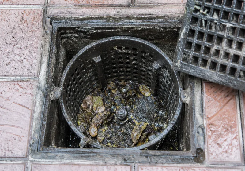 Imbornal de patio en Sevilla con rejilla abierta durante la limpieza de lodos