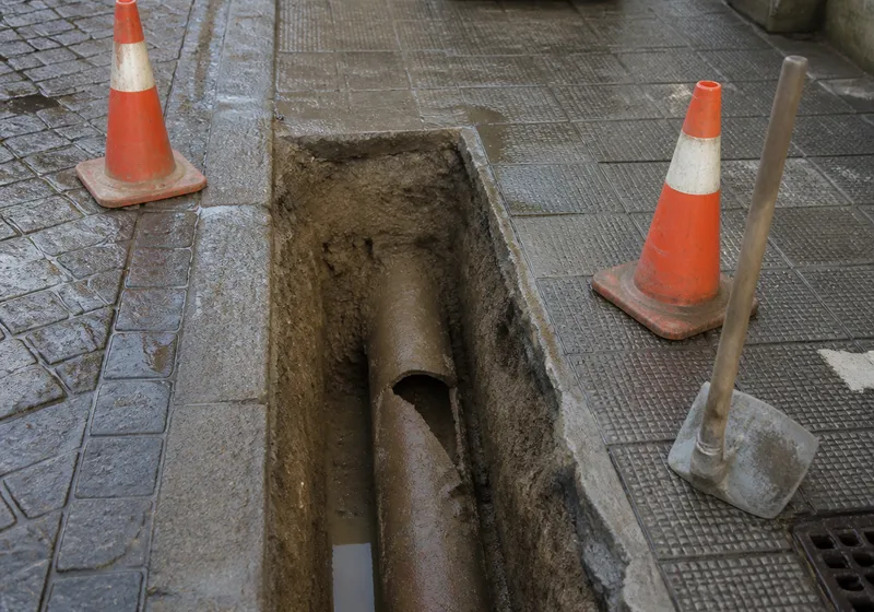 Zanja de reparación de alcantarillado en una acera de Sevilla, sin logos ni rostros